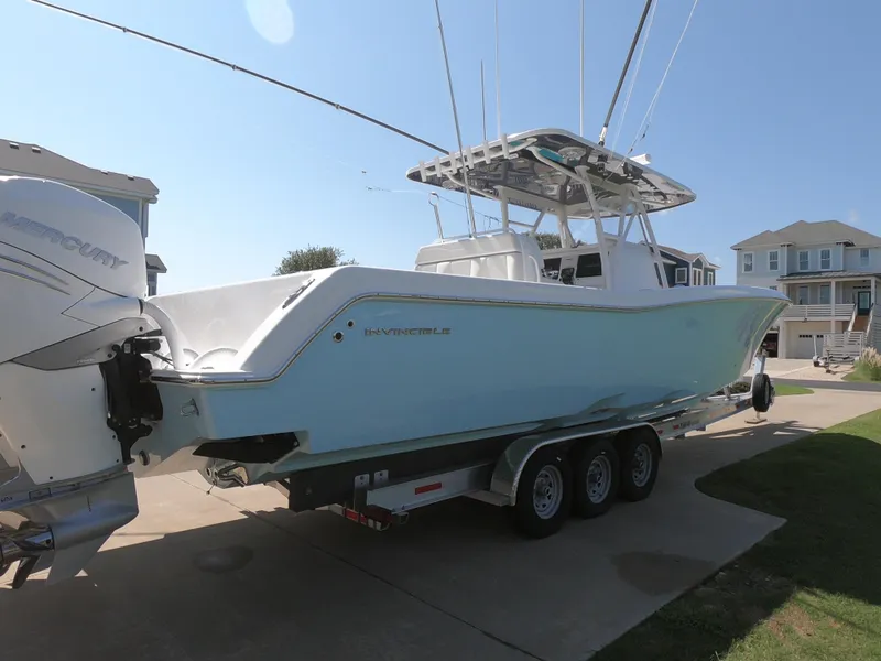 Slide: The Image of 2019 Invincible 39 CC boat on trailer, parked in residential driveway. - 7