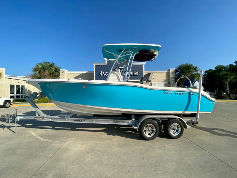 Slide: The Image of 2023 Key West 239 FS boat on a trailer in a parking lot. - 0