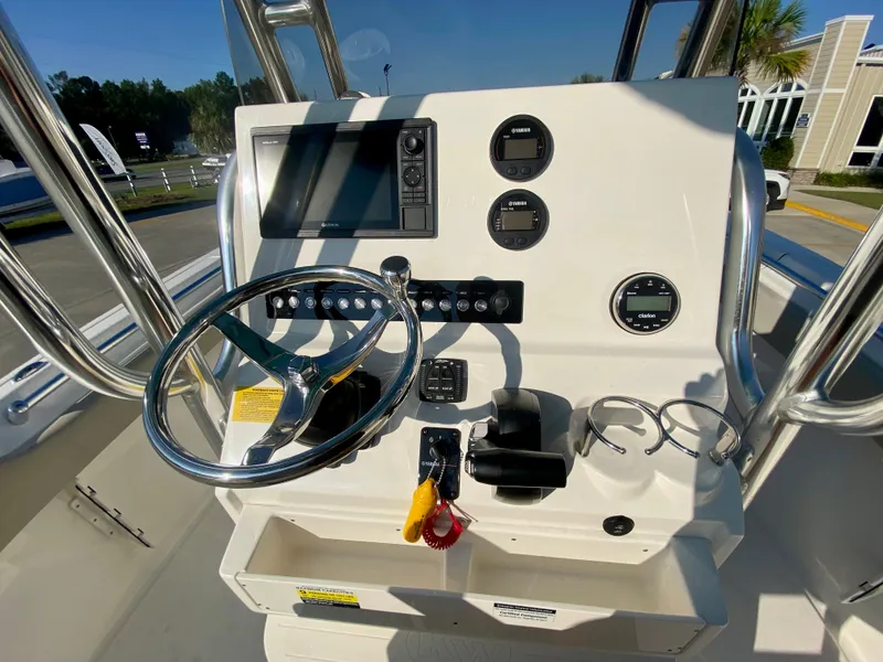 Slide: The Image of 2023 Key West 239 FS boat console with steering wheel, gauges, and navigation system. - 12