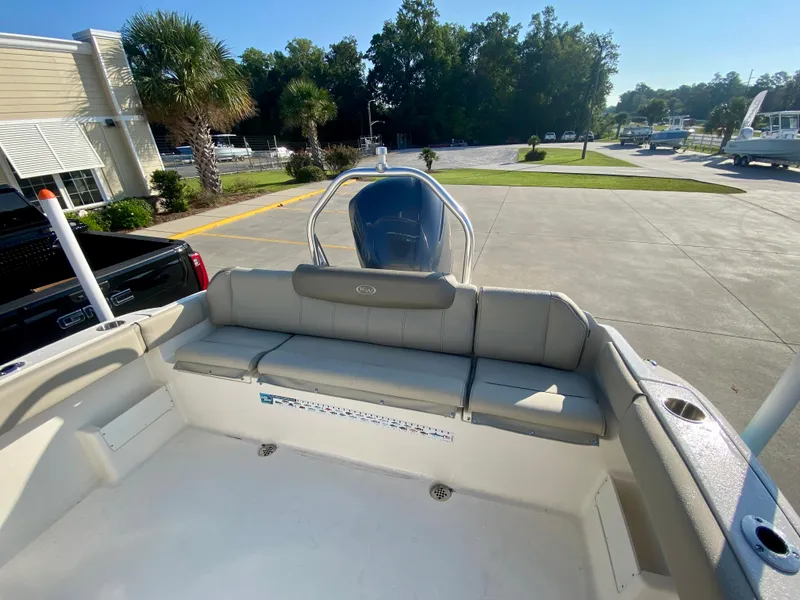 Slide: The Image of 2023 Key West 239 FS boat interior with seating and console, parked outdoors. - 6