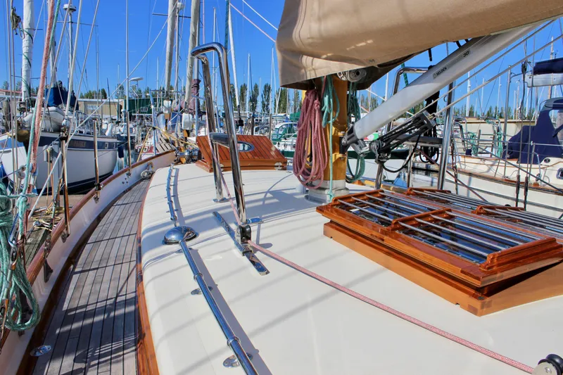 Slide: The Image of Sailboat deck of 2018 Cape George 45, featuring polished wood and rigging in a marina setting. - 11