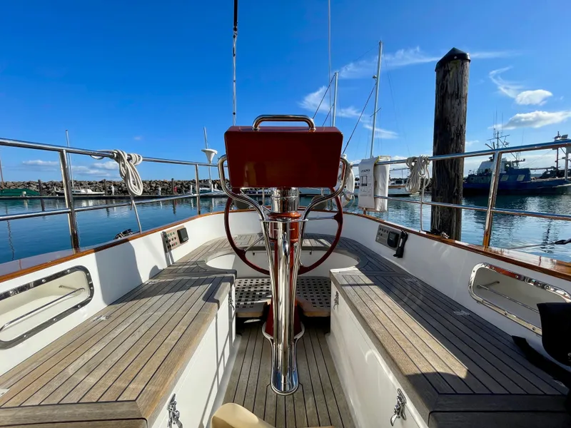 Slide: The Image of Cockpit of 2018 Cape George 45 sailboat with wooden deck and steering wheel, docked at marina. - 39
