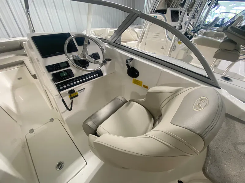 Slide: The Image of 2024 Key West 239 DFS boat cockpit with steering wheel and captain's chair. - 12