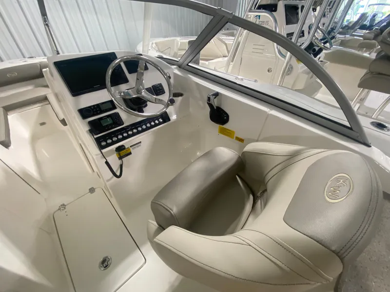 Slide: The Image of 2024 Key West 239 DFS boat interior with steering wheel and captain's seat. - 13