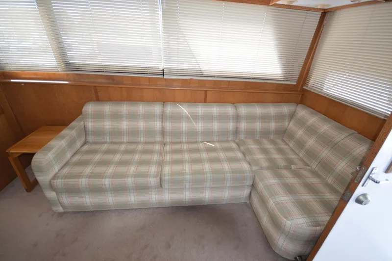 Slide: The Image of 1973 Hatteras 45 Convertible interior with plaid sofa and wooden accents - 16