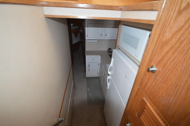 Slide: The Image of 1973 Hatteras 45 Convertible yacht interior kitchen with white cabinets and appliances. - 18