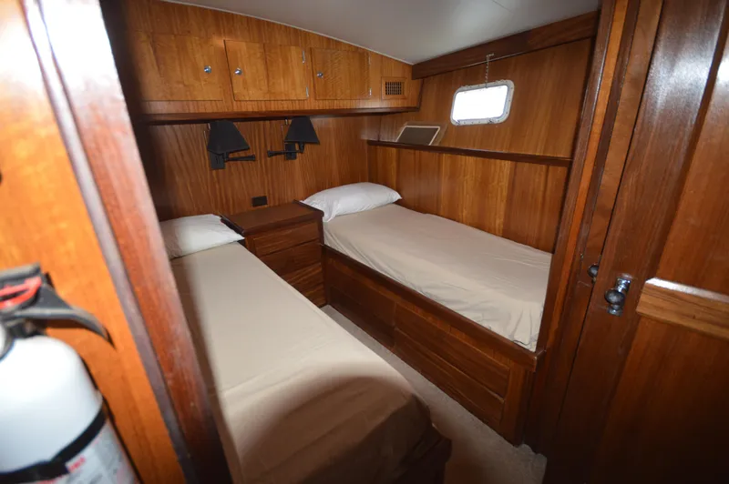 Slide: The Image of 1973 Hatteras 45 Convertible cabin with twin beds and wooden interior. - 20