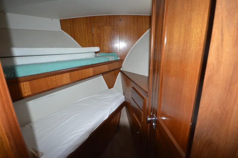 Slide: The Image of 1973 Hatteras 45 Convertible cabin with wooden bunk beds and storage. - 21