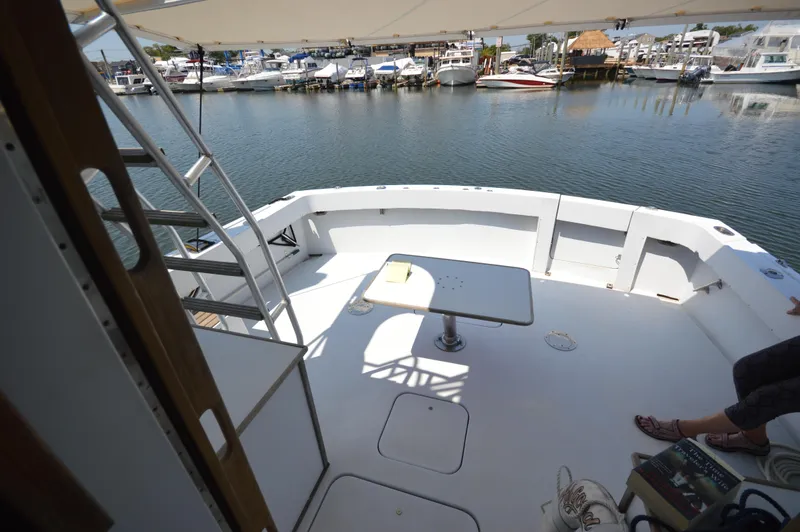 Slide: The Image of 1973 Hatteras 45 Convertible yacht deck with table, docked at marina. - 6