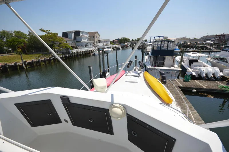 Slide: The Image of 1973 Hatteras 45 Convertible docked in a marina with kayaks on deck. - 9