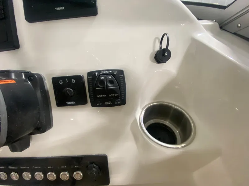 Slide: The Image of 2024 Key West 239 DFS boat dashboard with Yamaha controls and cup holder. - 17