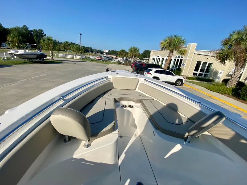 Slide: The Image of 2023 Key West 239 FS boat interior with seating, parked outdoors. - 19