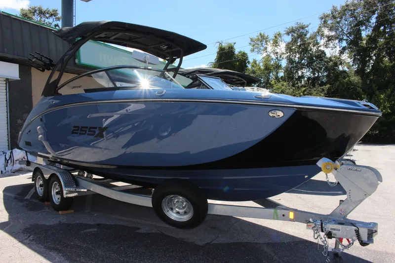 Slide: The Image of 2023 Yamaha Boats 255XD on trailer, sleek design, black and blue exterior. - 1