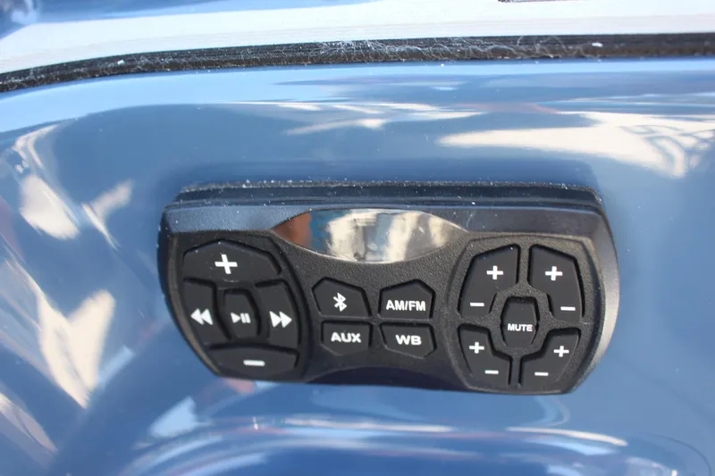 Slide: The Image of 2023 Yamaha Boats 255XD audio control panel with Bluetooth, AM/FM, AUX, and mute buttons. - 17