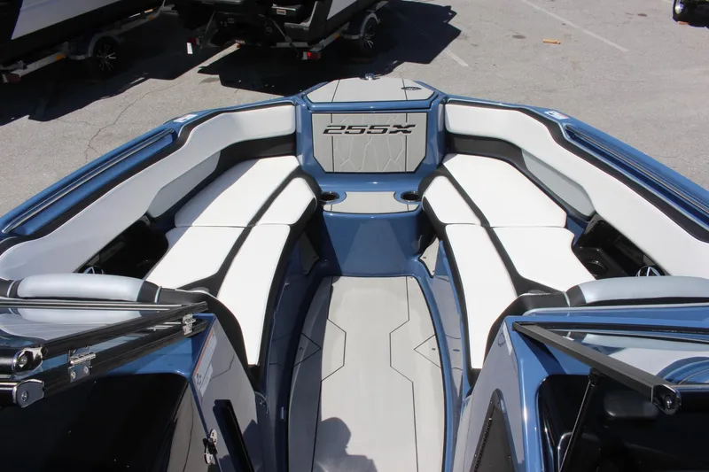 Slide: The Image of 2023 Yamaha Boats 255XD interior seating area with white and blue upholstery. - 5