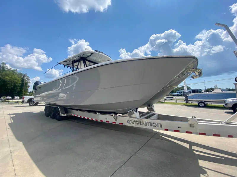 Slide: The Image of 2022 Invincible 35 Catamaran on a trailer under a sunny sky. - 2