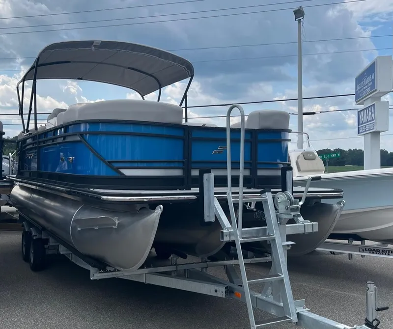 Slide: The Image of 2024 Starcraft SLS 3 pontoon boat on a trailer under a cloudy sky. - 12