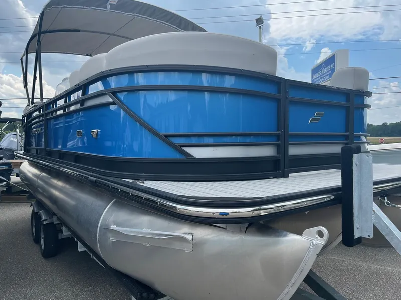 Slide: The Image of 2024 Starcraft SLS 3 pontoon boat with blue exterior on a trailer. - 3