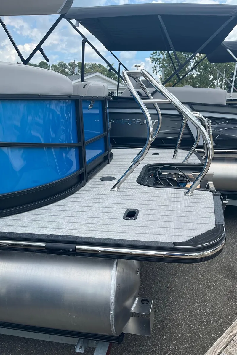 Slide: The Image of 2024 Starcraft SLS 3 pontoon boat with blue exterior and stainless steel ladder. - 5