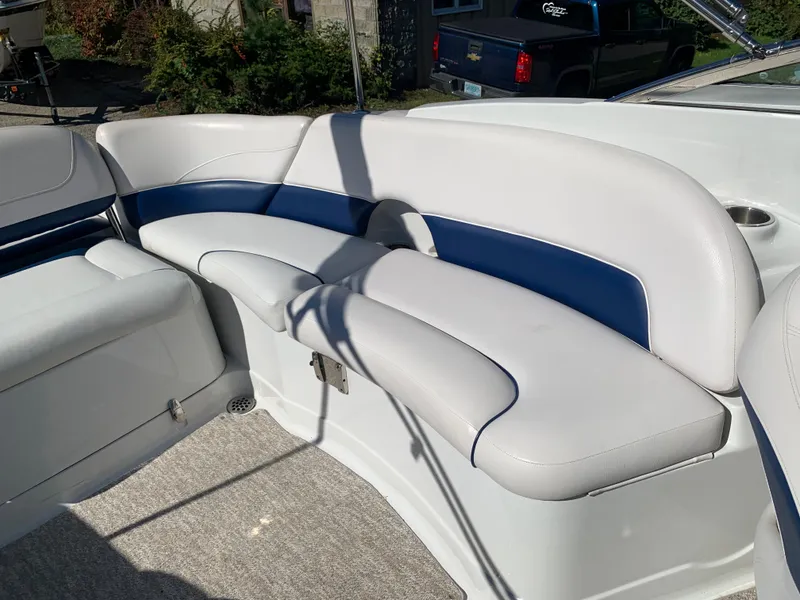 Slide: The Image of 2012 Crownline E6 boat interior with white and blue cushioned seating. - 20