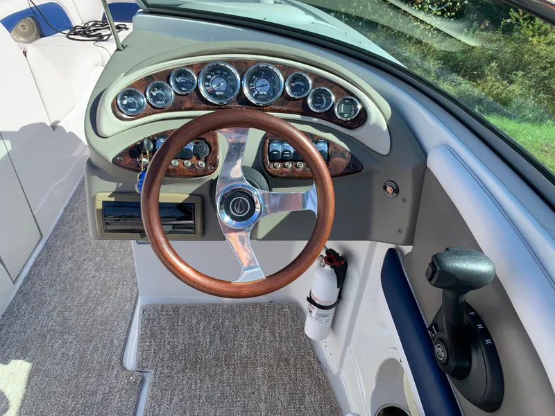 Slide: The Image of 2012 Crownline E6 boat dashboard with wooden steering wheel and instrument panel. - 29