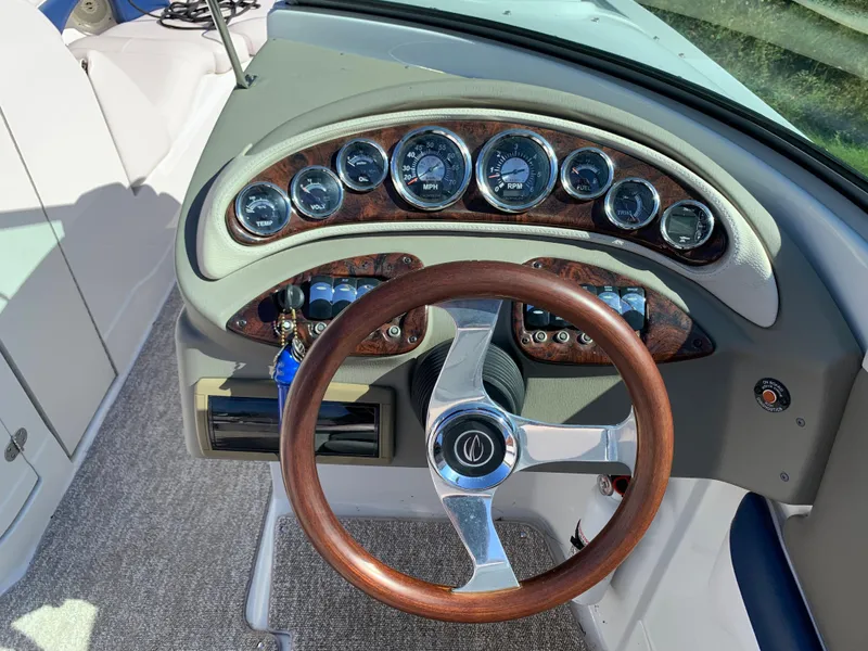 Slide: The Image of 2012 Crownline E6 boat dashboard with wood-trimmed steering wheel and instrument panel. - 30