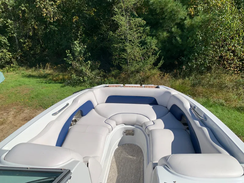 Slide: The Image of 2012 Crownline E6 boat with spacious seating area in a lush green setting. - 44
