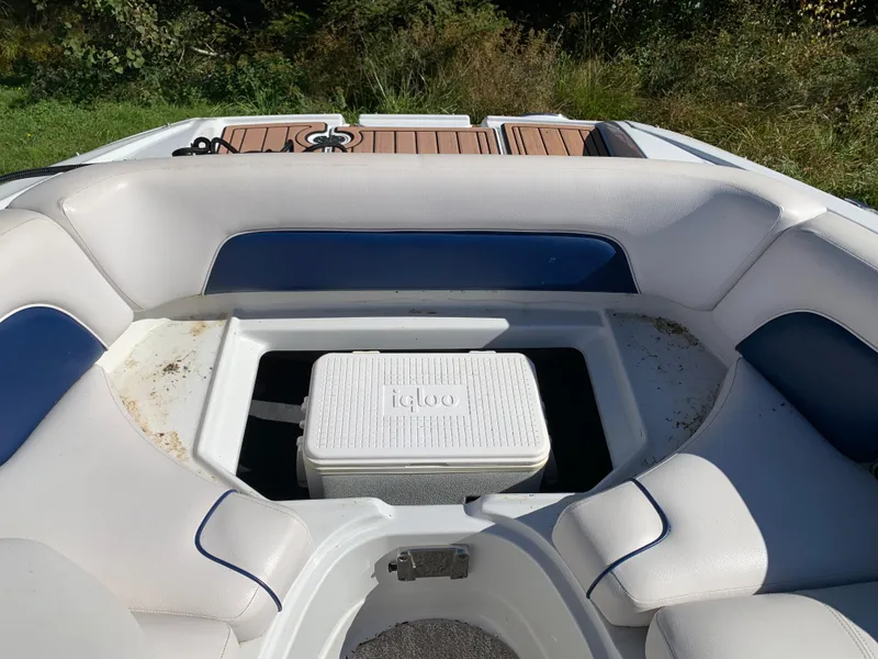 Slide: The Image of 2012 Crownline E6 boat interior with white and blue seating and Igloo cooler. - 49