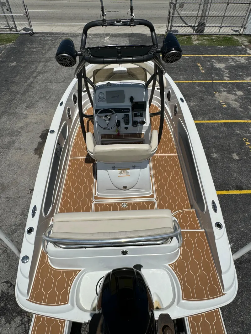 Slide: The Image of 2016 Pronautica 660 boat with tan deck, white seats, and black motor. - 12