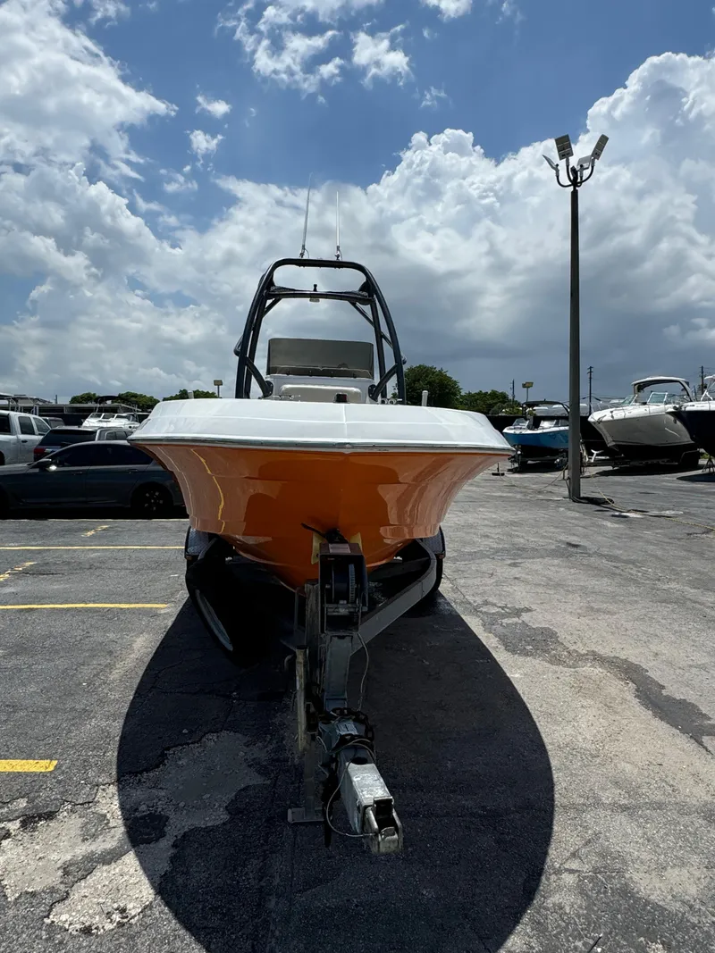 Slide: The Image of 2016 Pronautica 660 boat on trailer in a parking lot under a cloudy sky. - 18