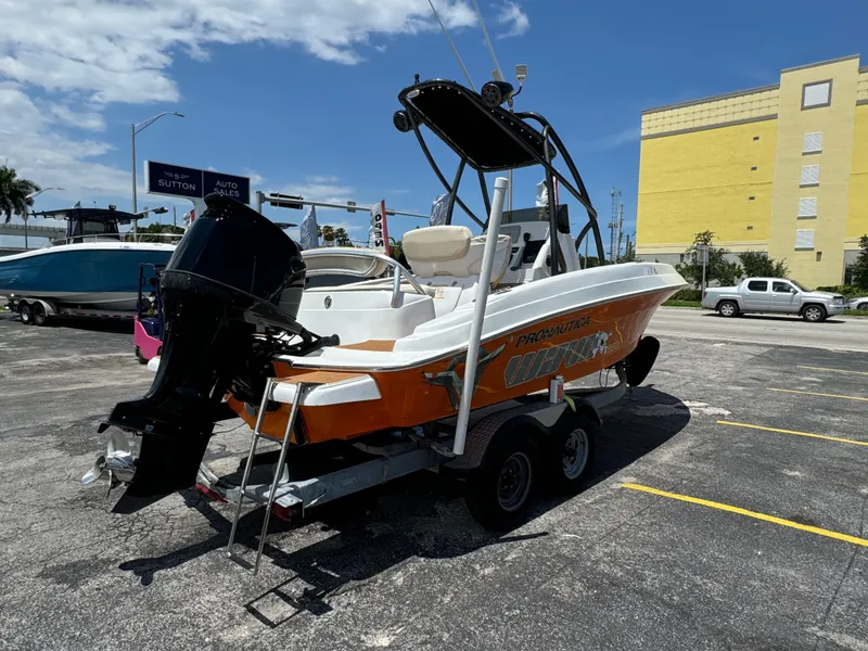 Slide: The Image of 2016 Pronautica 660 boat on trailer with outboard motor in parking lot. - 21