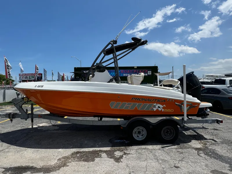 Slide: The Image of 2016 Pronautica 660 boat on a trailer under a clear blue sky. - 22