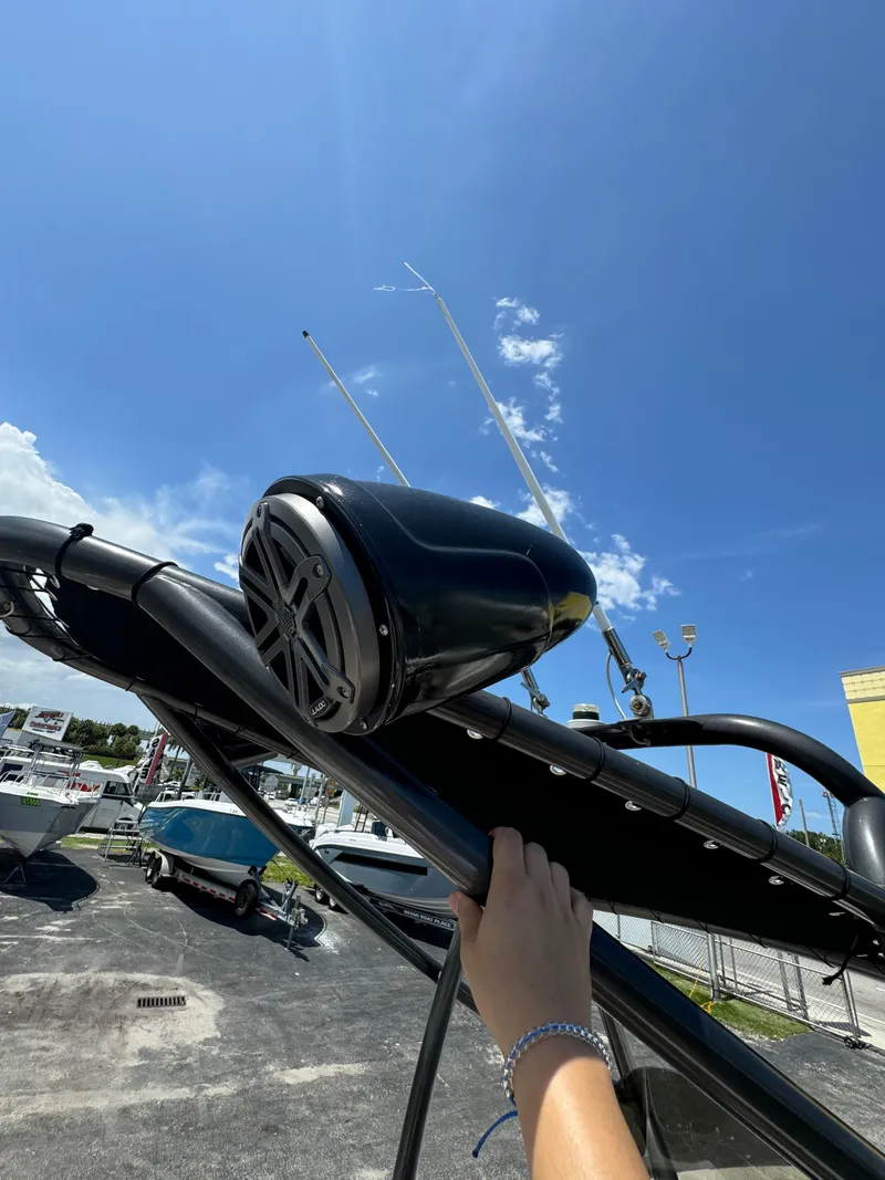 Slide: The Image of Hand adjusting speaker on 2016 Pronautica 660 boat under clear blue sky. - 35