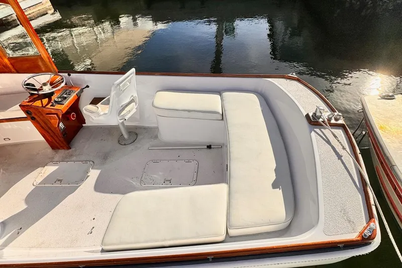 Slide: The Image of 1984 Duffy 20 Hardtop Diesel boat interior with white seating and wooden helm. - 9