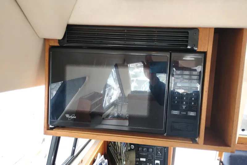 Slide: The Image of Microwave in 1995 Bayliner 3988 Motoryacht kitchen area, featuring wood cabinetry. - 23
