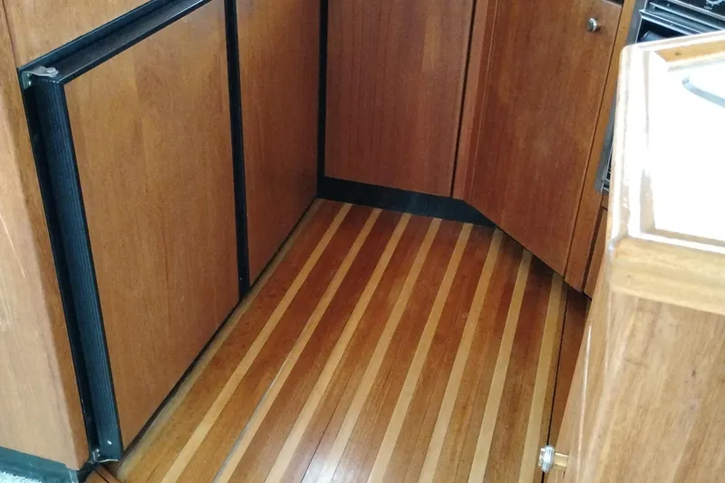 Slide: The Image of 1995 Bayliner 3988 Motoryacht interior with wood paneling and striped flooring. - 26