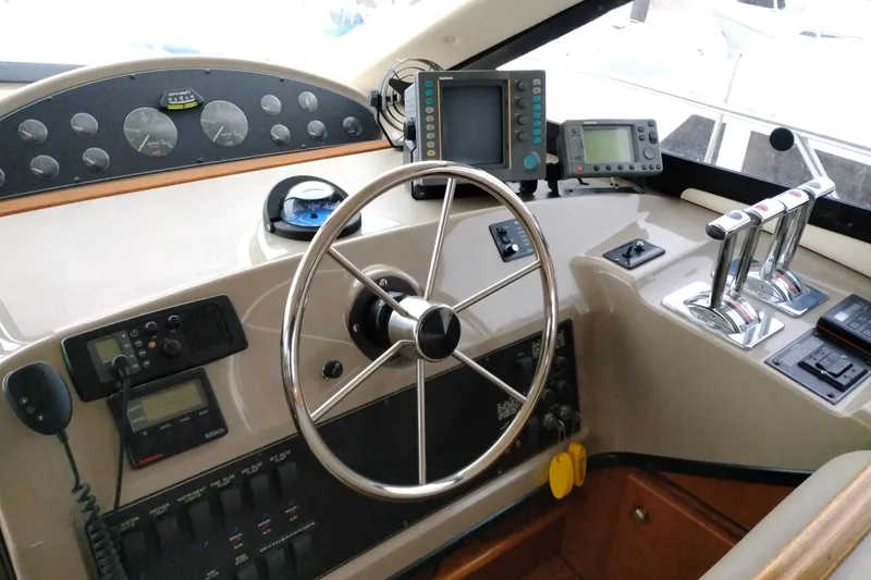 Slide: The Image of 1995 Bayliner 3988 Motoryacht helm with steering wheel, controls, and navigation instruments. - 28