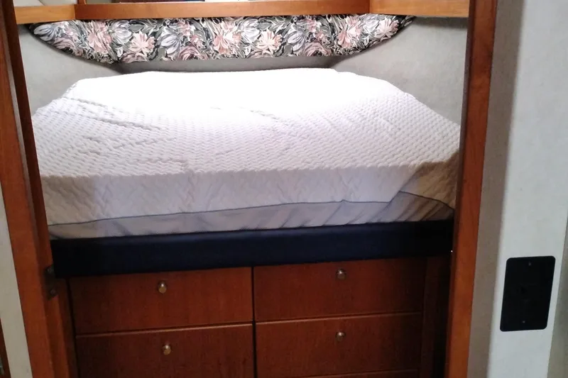 Slide: The Image of 1995 Bayliner 3988 Motoryacht bedroom with bed and wooden storage drawers. - 37