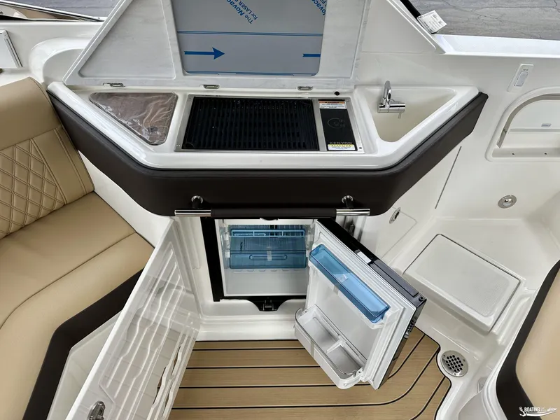 Slide: The Image of 2024 Sea Ray 310 SLX boat interior with kitchenette and open fridge. - 12