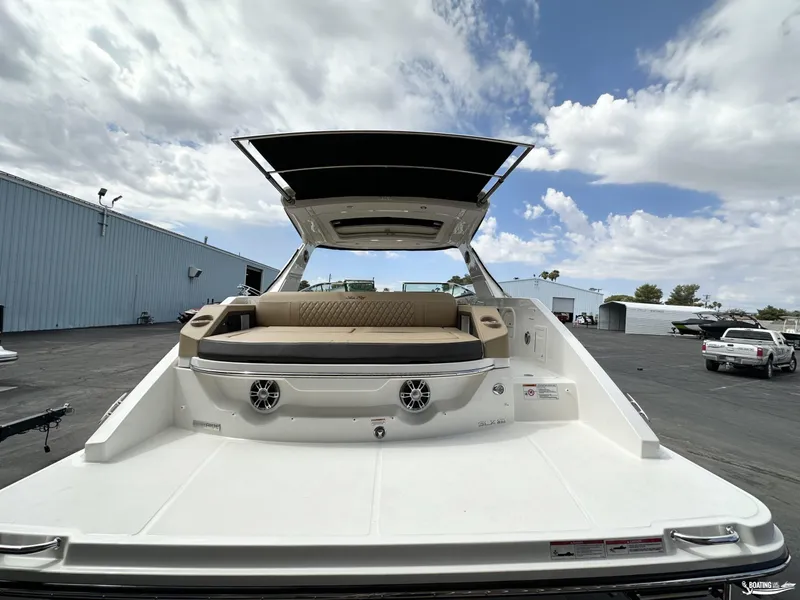 Slide: The Image of 2024 Sea Ray 310 SLX boat with spacious deck and seating, parked outdoors. - 3