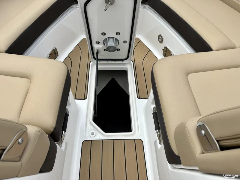 Slide: The Image of 2024 Sea Ray 310 SLX interior with beige seating and open storage compartment. - 9