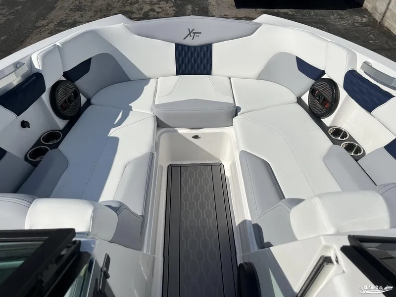 Slide: The Image of 2023 MasterCraft XT24 boat interior with white seating and cup holders. - 3