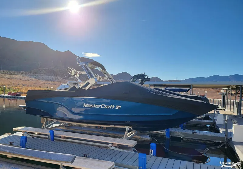 Slide: The Image of 2023 MasterCraft XT24 boat docked at marina under bright sun. - 7