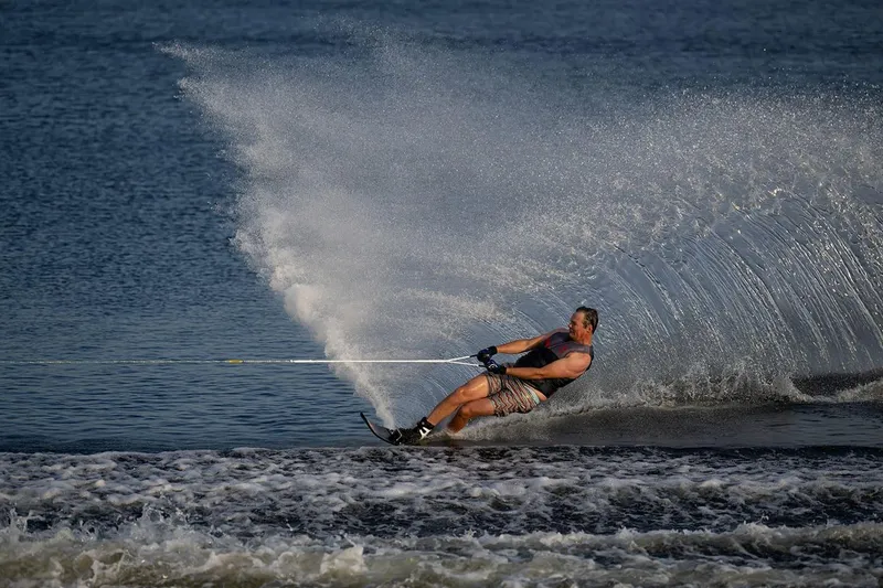 Slide: The Image of Man waterskiing behind 2024 Nautique GS22 boat on a lake. - 10