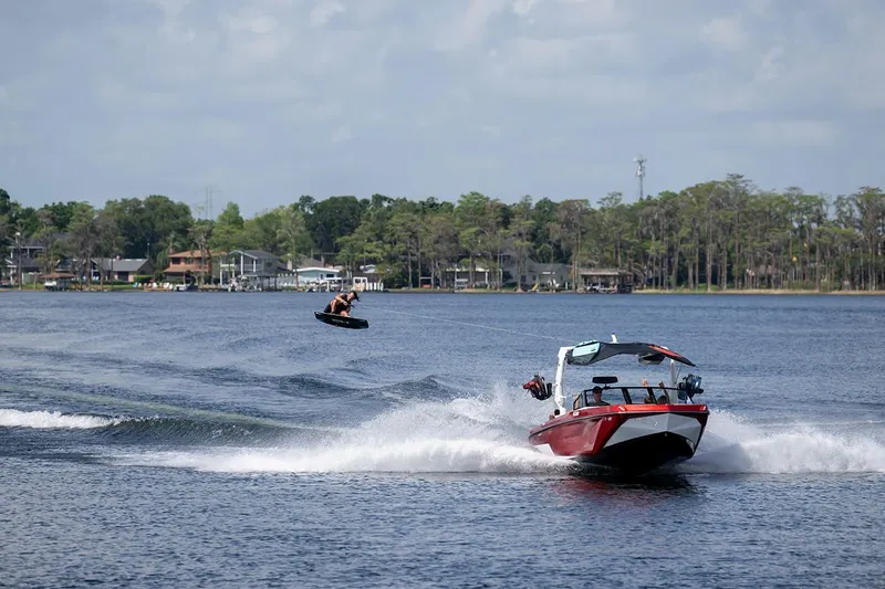 Slide: The Image of 2024 Nautique GS22 boat towing a wakeboarder on a lake. - 11