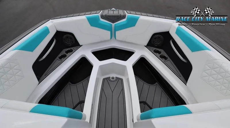 Slide: The Image of 2024 Nautique GS22 boat interior with teal and white seating, Race City Marine logo. - 15