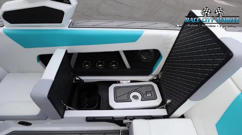Slide: The Image of 2024 Nautique GS22 boat interior with open storage compartments and teal accents. - 18