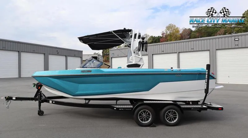 Slide: The Image of 2024 Nautique GS22 boat on trailer in front of storage units. - 2