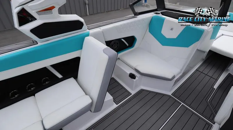 Slide: The Image of 2024 Nautique GS22 boat interior with white and teal seating, Race City Marine logo. - 20