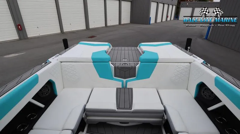 Slide: The Image of 2024 Nautique GS22 boat interior with white and turquoise seating. - 25